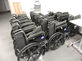 Three rows of folded manual wheelchairs