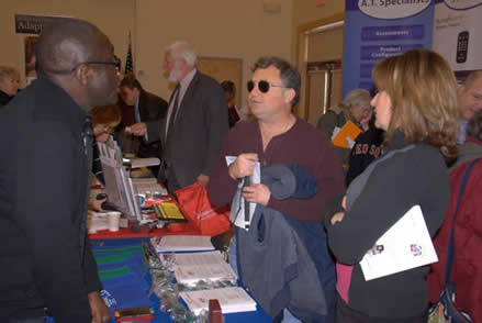 Exhibit hall at the Tech Fair with exhibitors talking with attendees.